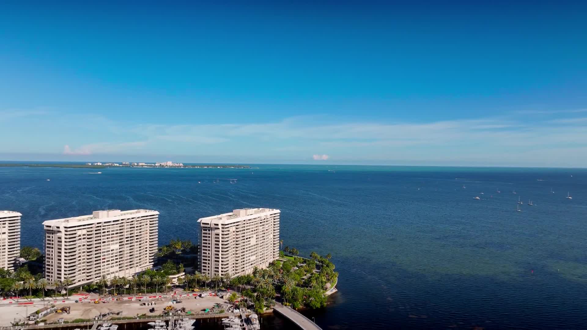 An aerial view over the South Florida coastline and waterfront condominium towers